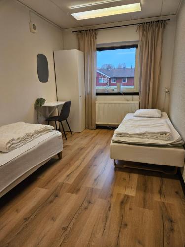 莫拉Saxvikens vandrarhem的配有书桌和窗户的客房内的两张床