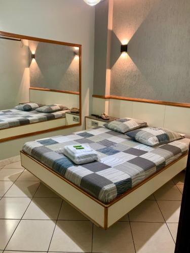 尼泰罗伊Hotel Glória的一间卧室设有两张床和大镜子