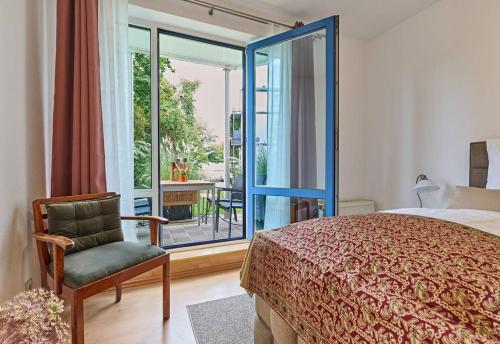 什未林Schelfstadtoase的卧室配有床、椅子和窗户。