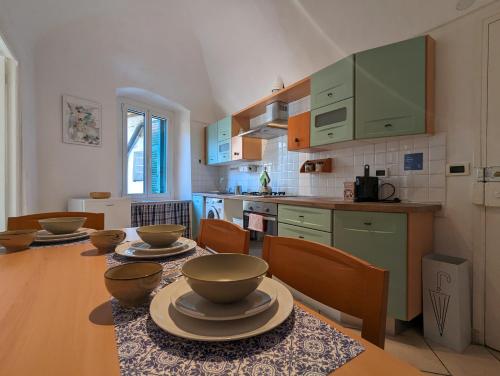 多尔切阿夸La Casa degli Alberi的厨房配有带碗的桌子
