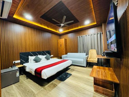 古瓦哈提N.K. Residency的一间卧室配有一张床、一台电视和一张沙发