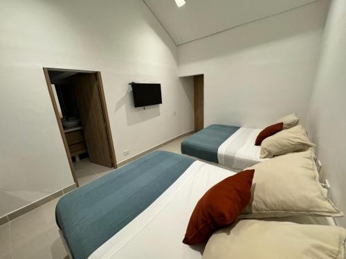 里考尔特Casa Privada en Exclusivo Club Privado的一间酒店客房,设有两张床和电视