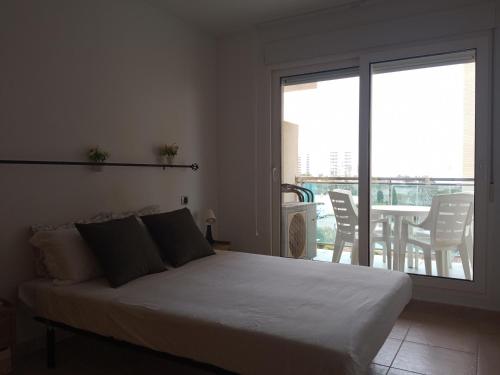 拉曼加戴尔马尔梅纳VENEZIOLA TRAVEL, relax & beach的一间卧室配有一张床,阳台配有桌子