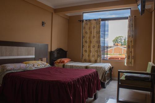 塔里哈Residencial Tablada的一间卧室设有两张床和大窗户