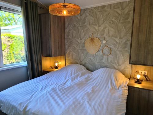 艾格蒙宾能Bungalowpark Mooyeveld的一间卧室配有白色的床和两盏灯