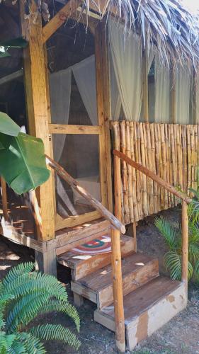 BombitaCasita de Madera Encuentro的一个带长凳和茅草屋顶的木制小屋