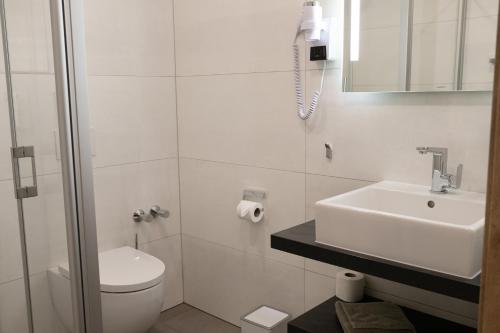 金策尔Landhaus Rhönblick的白色的浴室设有卫生间和水槽。