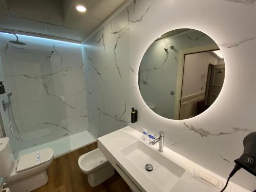 巴利亚多利德阿特里奥精品酒店的白色的浴室设有水槽和镜子