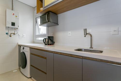 弗洛里亚诺波利斯WI-FI 300MB | Vista parcial do MAR #CAMP09的厨房配有水槽和洗衣机