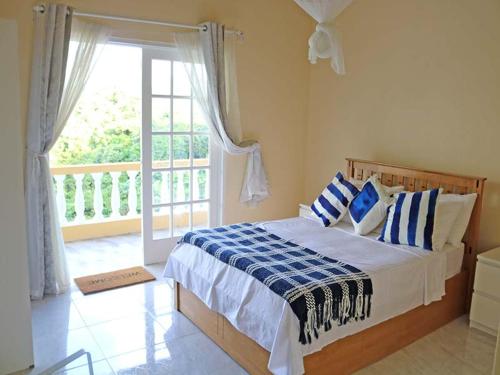 CaféVJ's Guesthouse Mountain View的一间卧室配有一张带蓝色和白色枕头的床