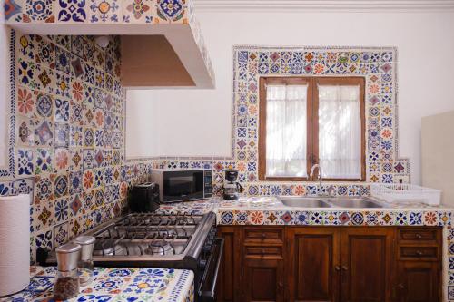 圣米格尔-德阿连德Casa Liza的厨房的墙壁上铺有蓝色和白色的瓷砖。