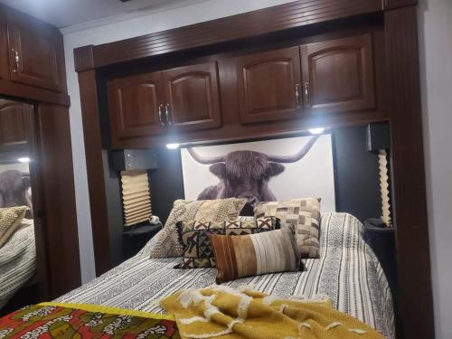 加特林堡Jolene的卧室配有一张床,墙上挂着一头牛的照片