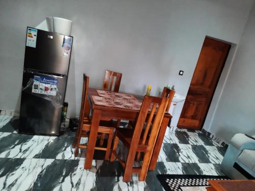 瓦加杜古Résidence kenzaina的厨房配有桌椅和冰箱。