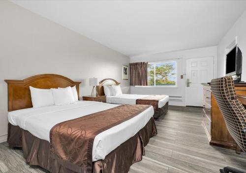 旧金山Motel 6 San Francisco, CA Great Highway的酒店客房设有两张床和一台平面电视。