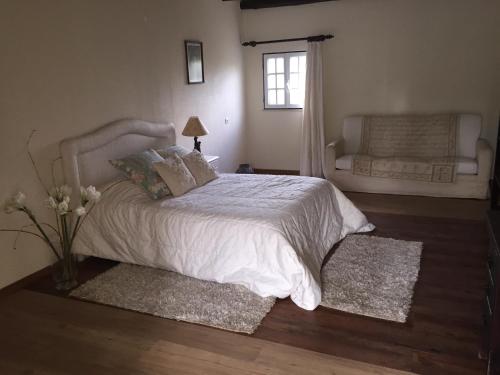塞图巴尔Casa do Jardim的卧室配有白色的床和窗户。