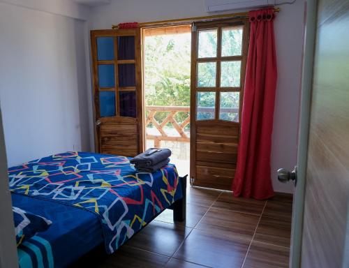 圣安特罗Cabañas en San Antero Bambumar2的一间卧室配有一张床,一扇门设有窗户