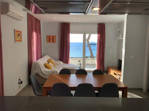 罗萨斯Veuràs el Mar - Almadrava Beach House的客厅配有桌子,享有海景