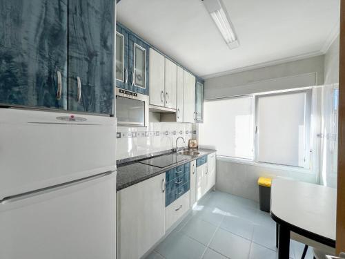 拉雷多Apartamento en Costa de Cantabria, Laredo的厨房配有白色橱柜和白色冰箱。