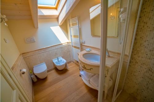 波佐伦戈Garda Residence San Vigilio的一间带水槽和卫生间的浴室以及窗户。