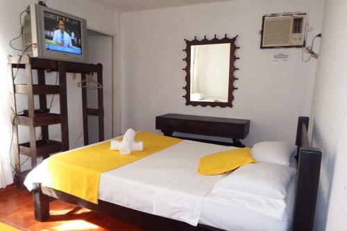 比亚维森西奥Torre del Sol的一间卧室配有一张带黄色毯子和镜子的床
