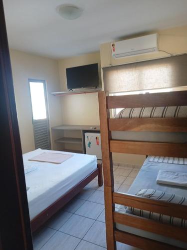 马塞约Poutur Pousada的客房设有两张双层床和电视。