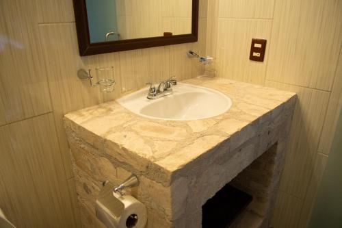 贝纳尔Hotel Boutique Sacramento的一间带大理石水槽和卫生纸饮水机的浴室