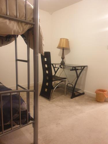 埃德蒙顿Residential property的一间卧室配有书桌和一张带椅子的床