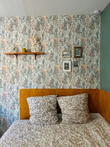 鲁昂Le Marguerite & Le Mélange Savant的一间卧室配有一张带花卉壁纸的床