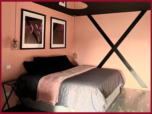 圣康坦03 LOVE ROOM By Fanny S的卧室配有一张床,墙上挂有两张照片
