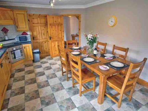 基拉尼Mountain View House的厨房以及带木桌和椅子的用餐室。
