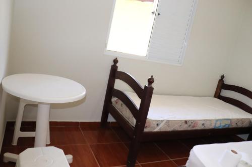博拉塞亚Camping Pousada Ilha do Mel - Frente ao Mar的小房间设有床、桌子和窗户