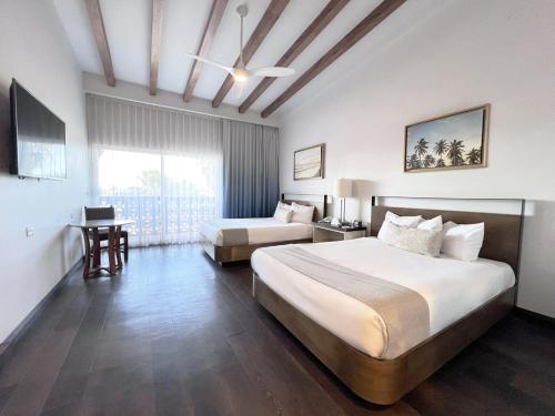 恩塞纳达港圣尼古拉斯赌场酒店的酒店客房设有两张床和窗户。