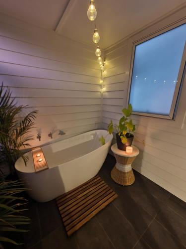 斯普林伍德Luxury private guest suite in the Blue Mountains的带浴缸的浴室和窗户。