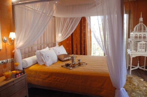 雅典Olympic Fashion Hotels的一间卧室配有一张天蓬床,并备有托盘