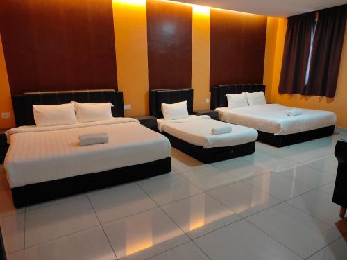 丹那拉打Tekoma Resort Cameron Highlands的黄色和橙色墙壁的客房内的两张床