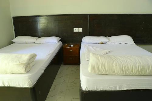 拉明德HOTEL GOLDEN BUDDHA的两张睡床彼此相邻,位于一个房间里