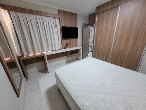 卡达斯诺瓦斯Piazza diRoma RM Hopedagem com Acesso Acqua Park/Splash的卧室配有白色的床和电视。
