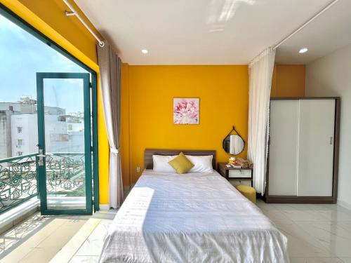 胡志明市Luxury Condotel Sai Gon 3的一间卧室设有一张床和黄色的墙壁