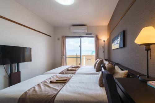 那霸KINTARO Hotel Okinawa Naha的酒店客房设有一张大床和大窗户