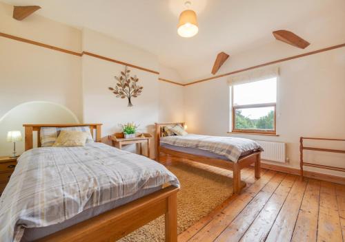 RuabonThe Old Farmhouse的一间卧室设有两张床和窗户。