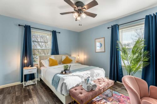 南本德Game Room - Firepit - V-ball -10 min to Notre Dame的一间卧室设有蓝色的墙壁和一张带吊扇的床。