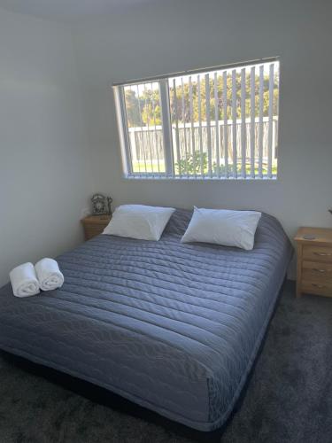 凯塔亚Wander Inn的卧室配有一张带两个枕头的床和窗户