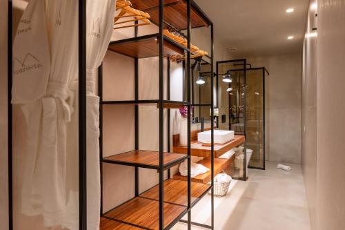 佩纳菲耶尔DOURWIN - Riverside Suites - Adults Only的客房内的带木制架子的浴室