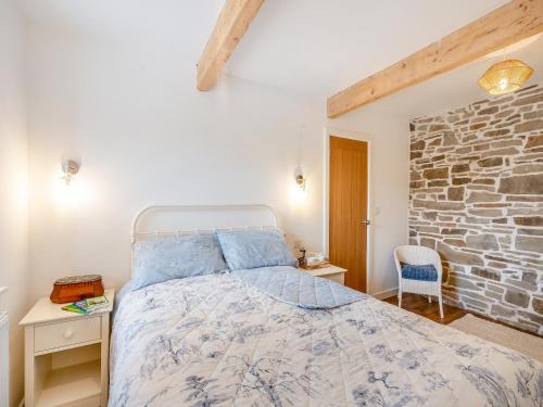 Winter Cottage的一间卧室设有一张床和石墙