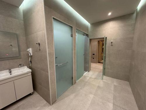 杜尚别IsraHotel Dushanbe的浴室设有玻璃门和水槽