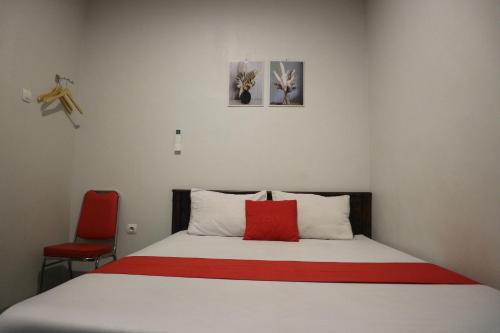 泗水K1 UPN的一间卧室配有一张红色枕头的床