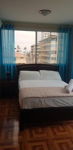 萨利纳斯Hostal Costa Linda Salinas的一间卧室设有一张床和一个大窗户