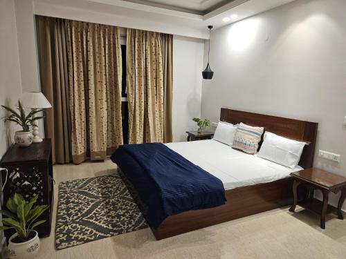 新德里Kali Bari View by Maple Key Stays - 3BHK & Terrace的一间卧室配有一张带蓝色毯子的大床