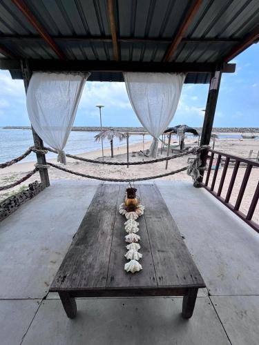 瓜拉丁加奴Rumahbatu beach cottage的海滩上的木桌和吊床