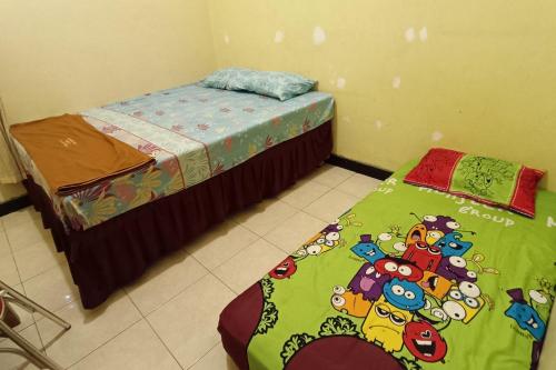 马格朗OYO 93660 New Family Hotel Syariah的一间卧室配有两张床和绿毯